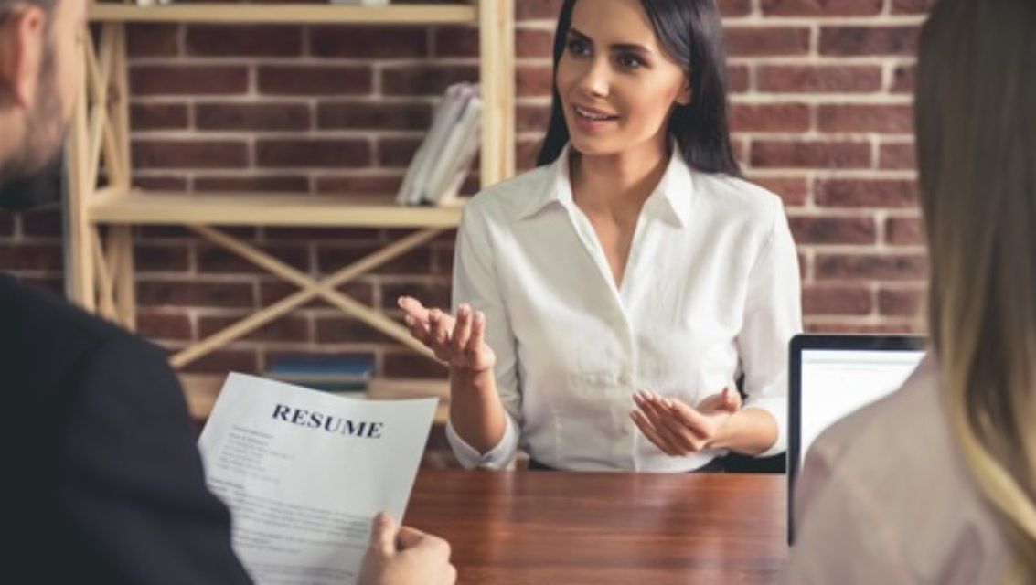 Tre kvinner i diskusjon på kontor